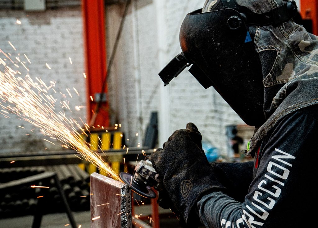 Equipo de maquinado CNC trabajando sobre pieza metálica cilíndrica con chispas durante el proceso.