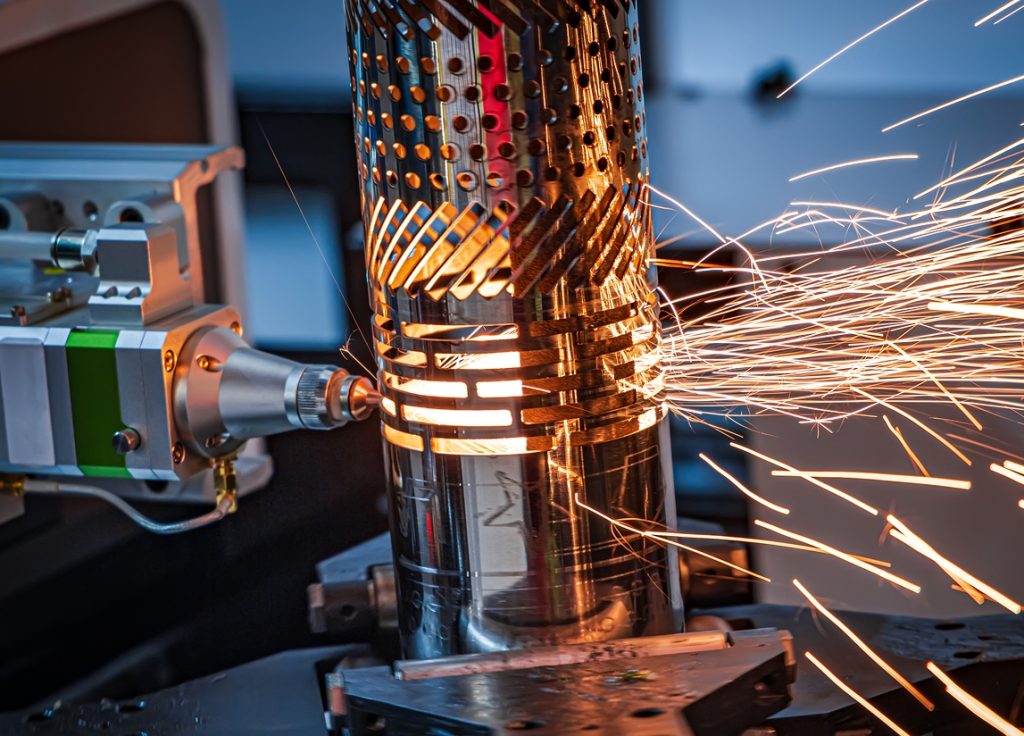 Maquinaria CNC realizando corte y maquinado de acero con chispas en taller industrial de TM ESTRUCTURAL en Mazatlán.